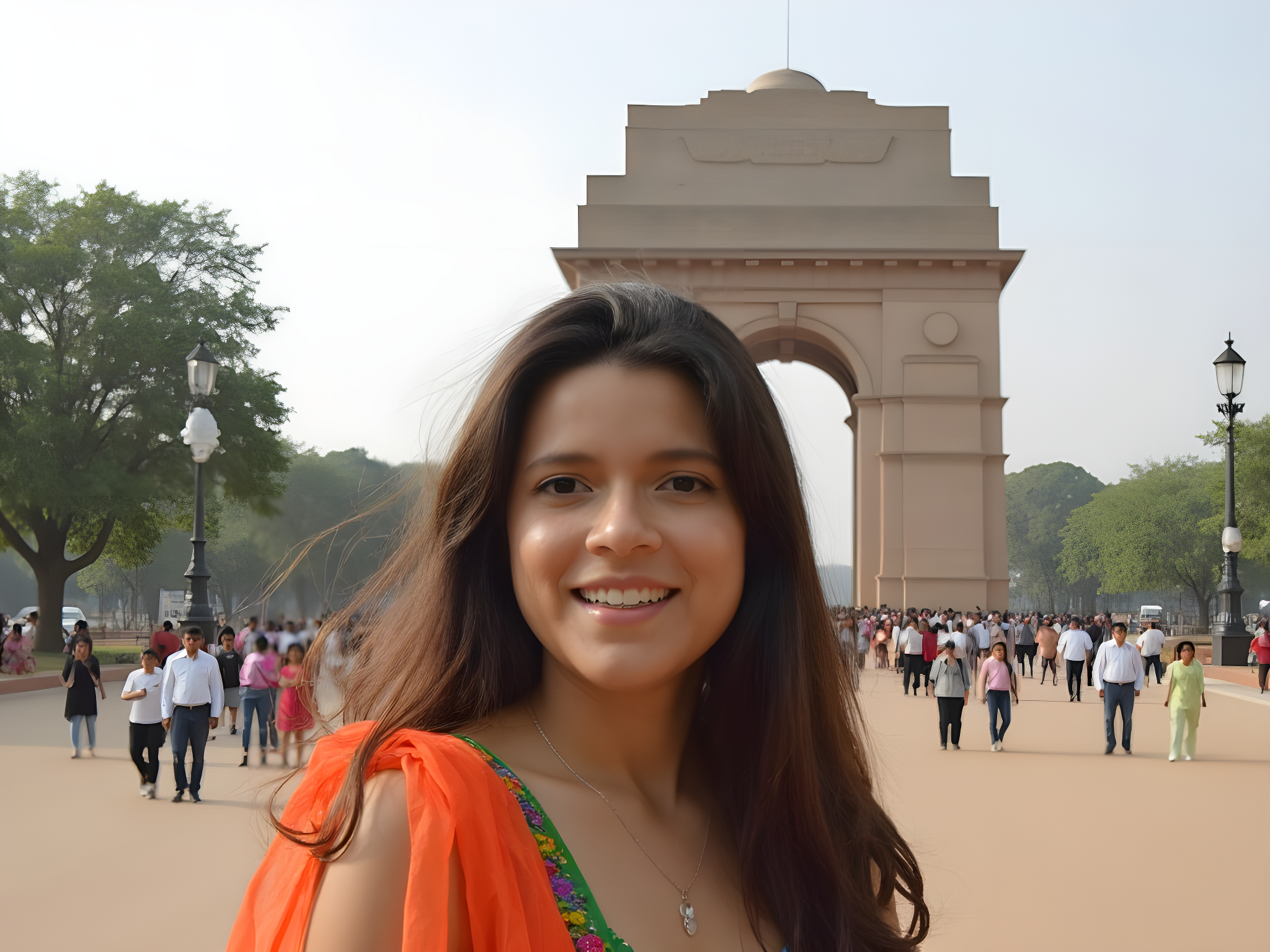 Smiling woman in traditional attire in front of India's iconic India Gate, surrounded by visitors and lush greenery.